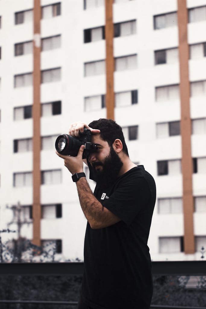 Photographer capturing urban scenes outdoors with focus and style.